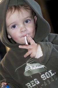 Young boy smoking a cigarette sweet